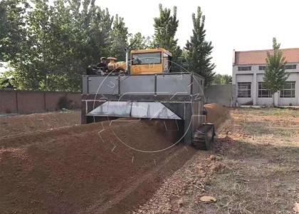 The crawler type compost turner is turning over the piled horse manure